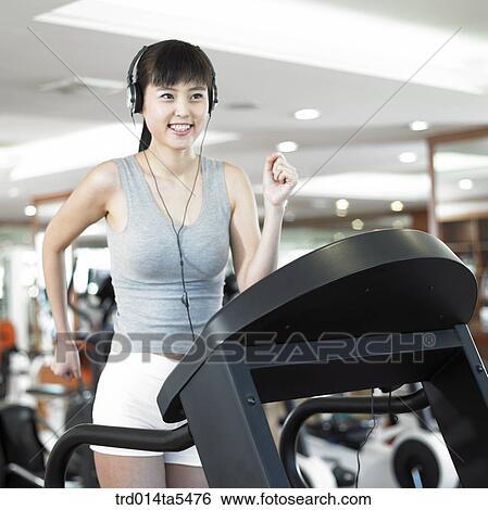 a running woman on a running machine at a fitness club View Large Photo Image Stock Photograph - a running woman on a running machine at a fitness club. Fotosearch