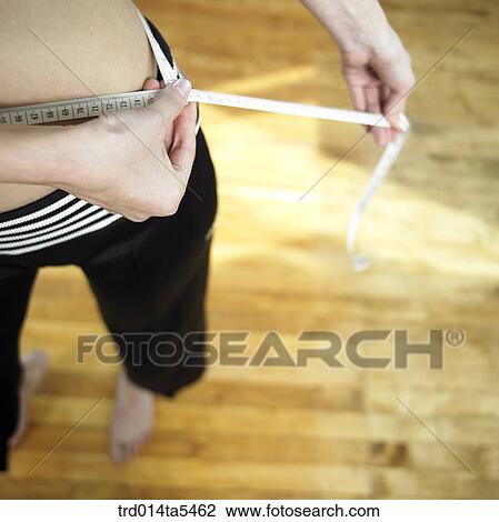 a woman measuring her waist View Large Photo Image Stock Image - a woman measuring her waist . Fotosearch