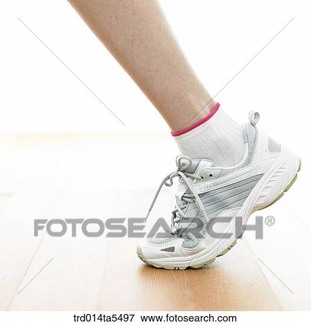 Stock Photo - a woman's feet wearing running shoes. Fotosearch
