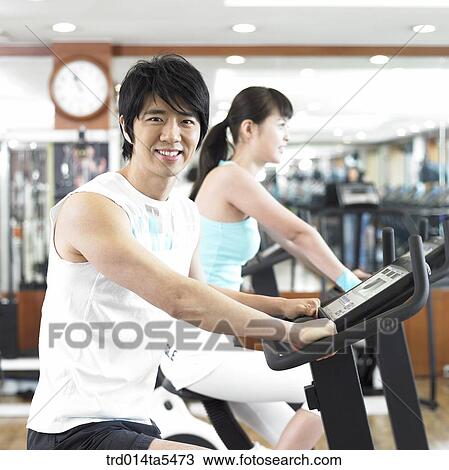 Stock Image - an exercising couple at a fitness club. Fotosearch