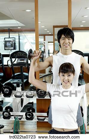 Stock Image - an exercising couple at a fitness club. Fotosearch