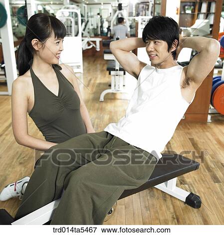 Stock Photo - an exercising couple at a fitness club. Fotosearch