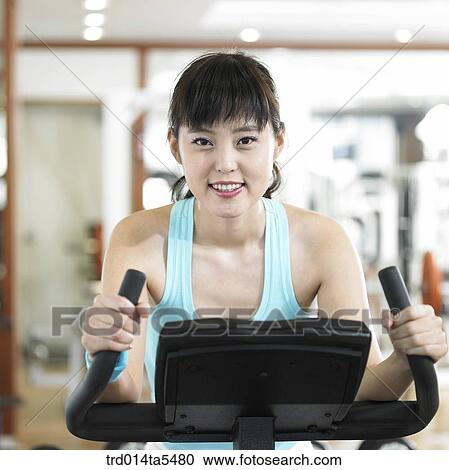 an exercising woman at a fitness club View Large Photo Image Stock Image - an exercising woman at a fitness club. Fotosearch