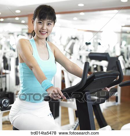 Stock Photo - an exercising woman at a fitness club. Fotosearch