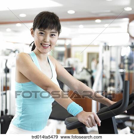 an exercising woman at a fitness club View Large Photo Image Stock Photo - an exercising woman at a fitness club. Fotosearch