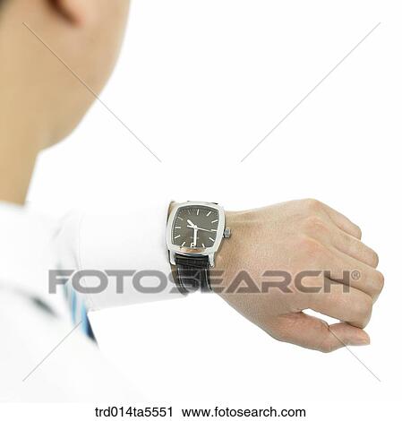 business concept/ a businessman looking at a watch View Large Photo Image Stock Image - business concept/ a businessman looking at a watch. Fotosearch