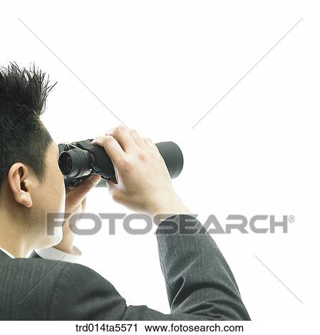 Stock Image - business concept/a businessman looking through a telescope. Fotosearch