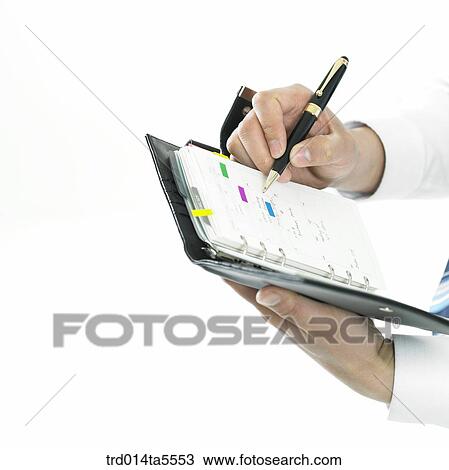 business concept/a businessman's hand writing something on a diary View Large Photo Image Stock Image - business concept/a businessman's hand writing something on a diary. Fotosearch
