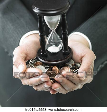 business concept/a businessman's hand full of coins and hourglass View Large Photo Image Stock Photo - business concept/a businessman's hand full of coins and hourglass. Fotosearch