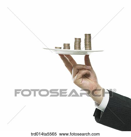 Stock Photography - business concept/a businessman's hand holding a coin tower on a dish. Fotosearch