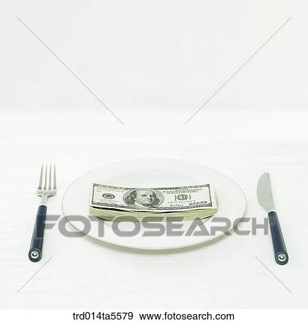 Stock Photo - business concept/a paper money, a fork and a knife on a dish. Fotosearch
