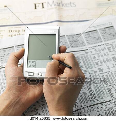 Stock Photography - business concept/a PDA and an electric pen on a newspaper. Fotosearch