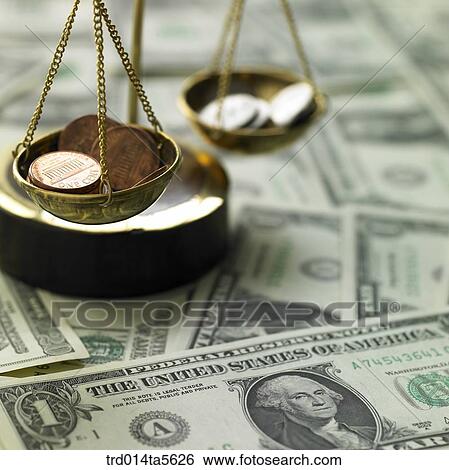 Stock Photograph - finance/a scale and coins on a paper money . Fotosearch