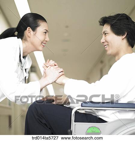 Stock Photo - medicine/ a dentist and a patient on a wheelchair. Fotosearch
