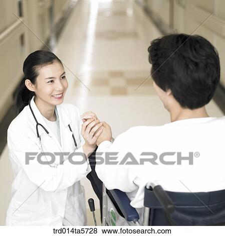 Stock Photo - medicine/ a dentist and a patient on a wheelchair. Fotosearch