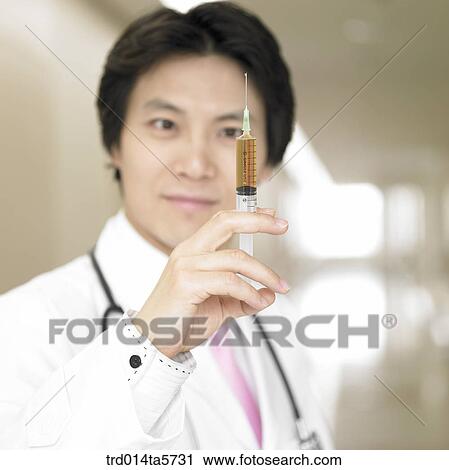 medicine/ a doctor holding an injector View Large Photo Image Stock Image - medicine/ a doctor holding an injector. Fotosearch