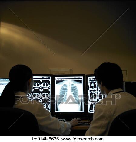 Stock Photograph - medicine/ a doctor looking at MRI pictures. Fotosearch