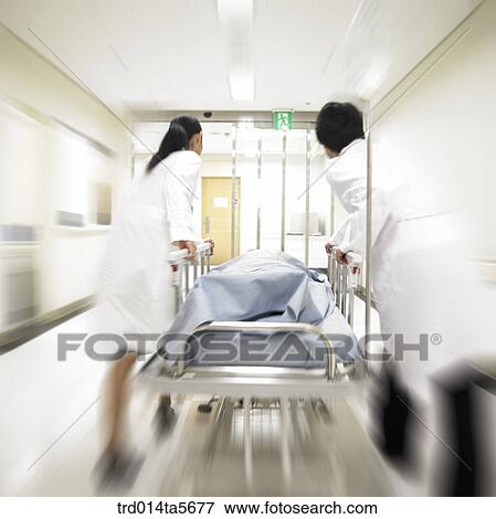 Stock Photo - medicine/ a doctor moving an emergent patient. Fotosearch