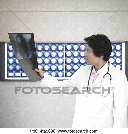 Stock Image - medicine/ a doctor with X-ray photographs. Fotosearch