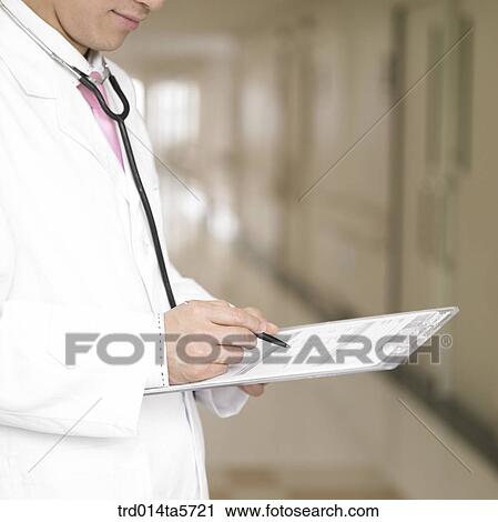 Stock Image - medicine/ a doctor writing a medical chart. Fotosearch