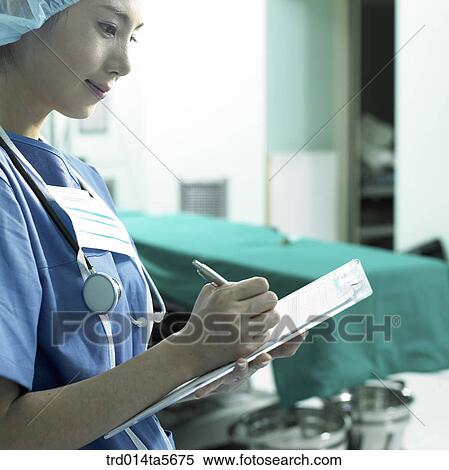 Stock Photography - medicine/ a doctor writing a medical chart. Fotosearch