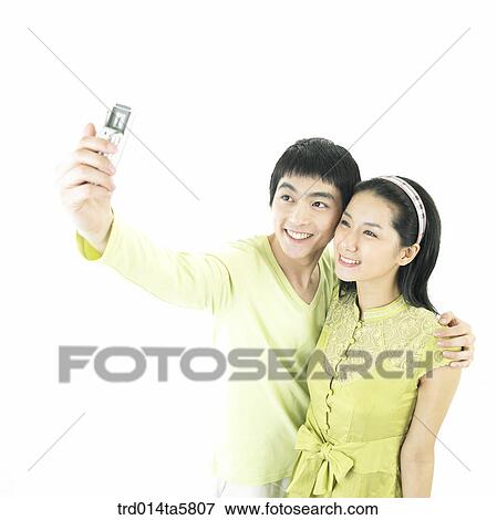 Stock Photo - a couple taking a picture. Fotosearch