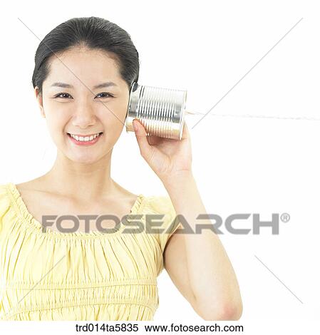 a smiling woman playing with a can View Large Photo Image Stock Photography - a smiling woman playing with a can. Fotosearch