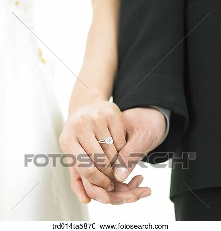 a bride wearing a wedding ring and a bridegroom holding her hands View Large Photo Image Stock Image - a bride wearing a wedding ring and a bridegroom holding her hands . Fotosearch