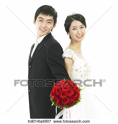 Stock Photo - a bridegroom and a bride with a bouquet. Fotosearch