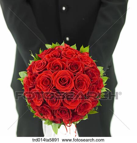 Stock Image - a bridegroom holding a bouquet. Fotosearch
