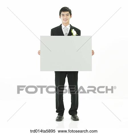 Stock Photography - a bridegroom holding a cardboard. Fotosearch