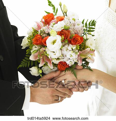 Picture - a bridegroom with a bouquet and a bride's hands. Fotosearch