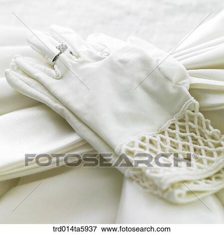 Stock Photo - a bride's gloves and a wedding ring on the table. Fotosearch