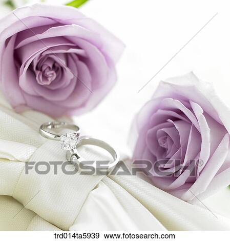 a wedding ring and flowers on the table View Large Photo Image Stock Photo - a wedding ring and flowers on the table. Fotosearch