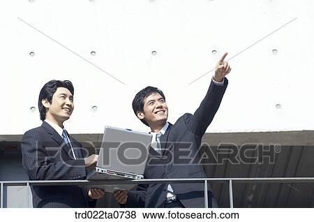 a businessman and his colleague using a notebook View Large Photo Image Stock Photo - a businessman and his colleague using a notebook. Fotosearch
