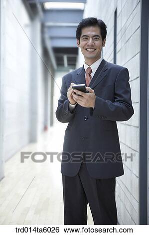 a businessman holding a PDA View Large Photo Image Stock Photograph - a businessman holding a PDA. Fotosearch