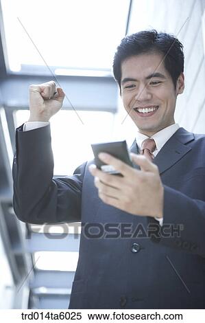 a businessman holding a PDA View Large Photo Image Stock Photography - a businessman holding a PDA. Fotosearch