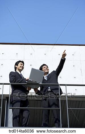 a businessman with a notebook and his colleagues View Large Photo Image Stock Photograph - a businessman with a notebook and his colleagues. Fotosearch