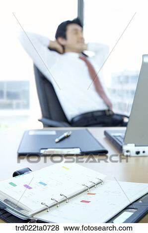 Stock Photo - a businessman with business supplies. Fotosearch