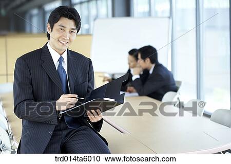 Stock Image - a businesswoman and a businessman in a conference room. Fotosearch