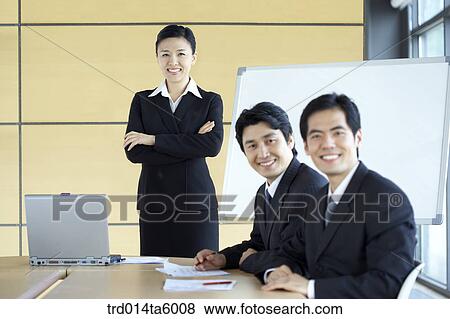 Stock Photo - a businesswoman and a businessman in a conference room. Fotosearch