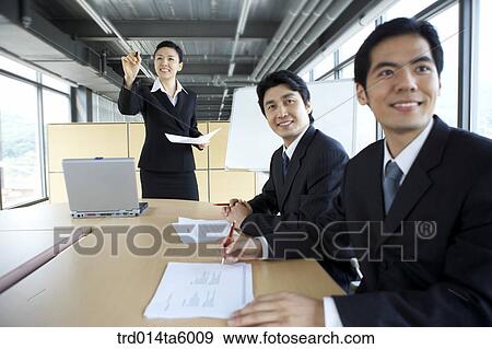 Stock Photo - a businesswoman and a businessman in a conference room. Fotosearch