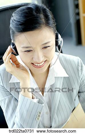Stock Image - a businesswoman consulting with a headset. Fotosearch