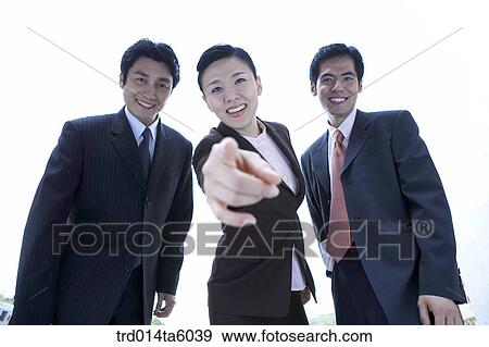 a businesswoman pointing at something and a smiling businessman View Large Photo Image Stock Photo - a businesswoman pointing at something and a smiling businessman. Fotosearch