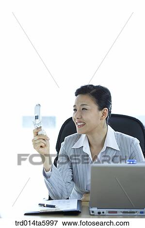 a businesswoman using a mobile phone View Large Photo Image Stock Photo - a businesswoman using a mobile phone. Fotosearch