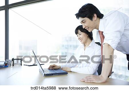 a businesswoman working with a notebook and a businessman View Large Photo Image Stock Photo - a businesswoman working with a notebook and a businessman. Fotosearch