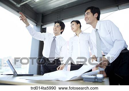 Stock Image - a explaining businessman and hearing colleagues. Fotosearch
