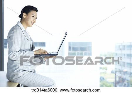 Stock Image - a typing businesswoman . Fotosearch