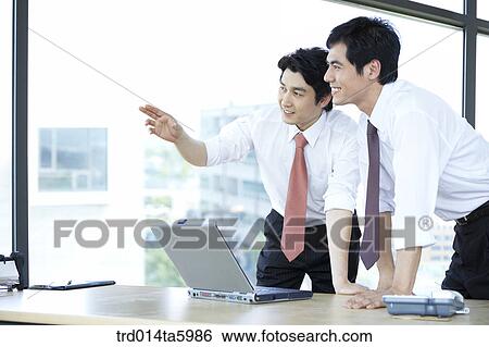 Stock Photograph - an explaining businessman and a hearing businessman. Fotosearch