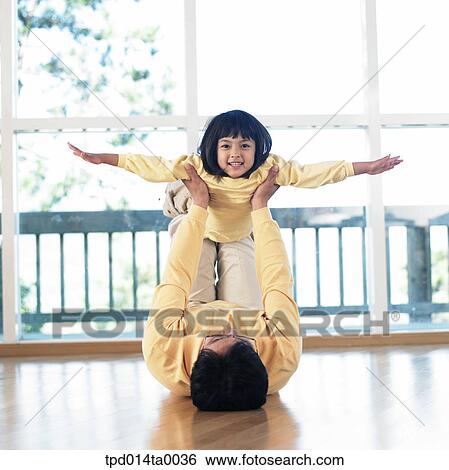 Stock Photograph - living room, play, lying, Asian, daughter, airplane. Fotosearch